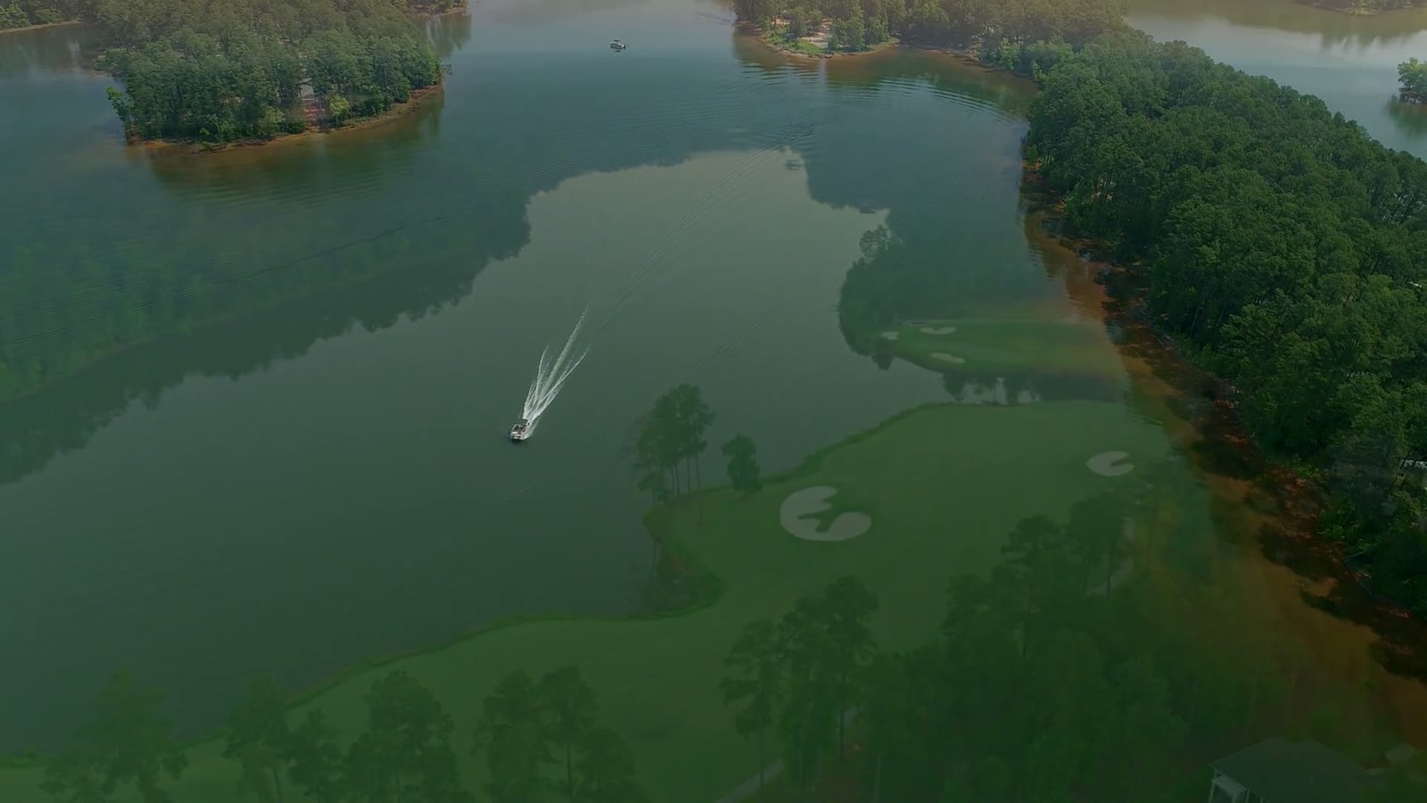 Actual aerial footage still of wooded lakeshore and golf landscape