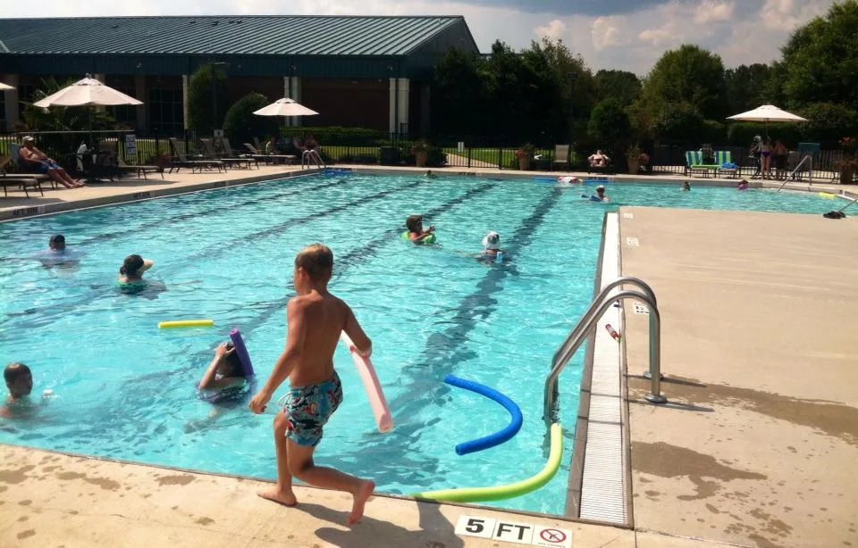 Actual photograph of swimmers and an aquatic class in the outdoor pool