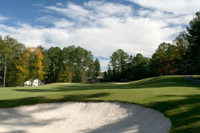 Photograph of a bunker in the foreground of a Tara hole with homes and trees on the ridge